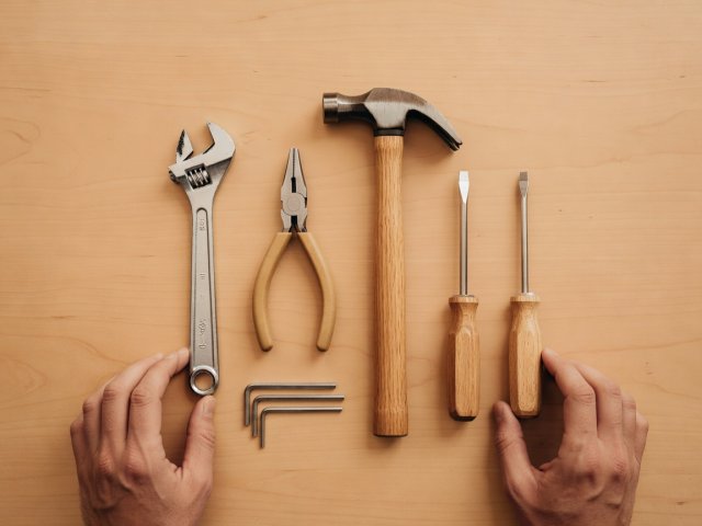 Compact set of hand tools arranged on a clean neutral background